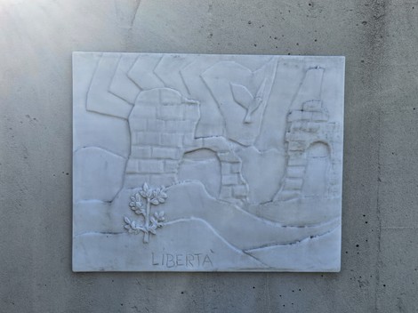 Monumento alla Resistenza con figure stilizzate e un albero, simbolo di libertà e resistenza.