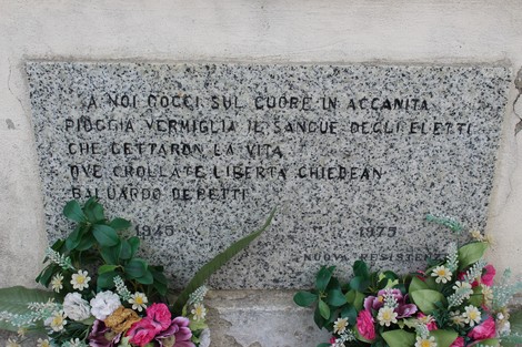 Sacrario dei partigiani con lapide commemorativa e fiori. Rappresenta il ricordo dei caduti per la libertà.