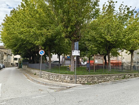Un giardino pubblico con alberi, simbolo di resistenza e memoria antifascista, in un contesto urbano.