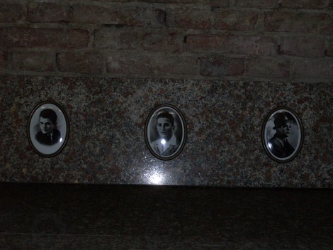 Sacrario dei caduti di Luzzara con fotografie commemorative su una base in marmo.