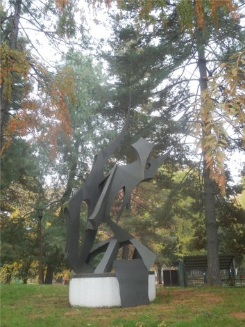 Monumento alla Resistenza: scultura moderna circondata da alberi, simbolo di libertà e lotta per i diritti.