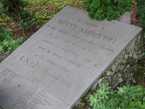 Lapide commemorativa dedicata a Betty Ambiveri e ai partigiani di Seriate, situata in un contesto naturale.