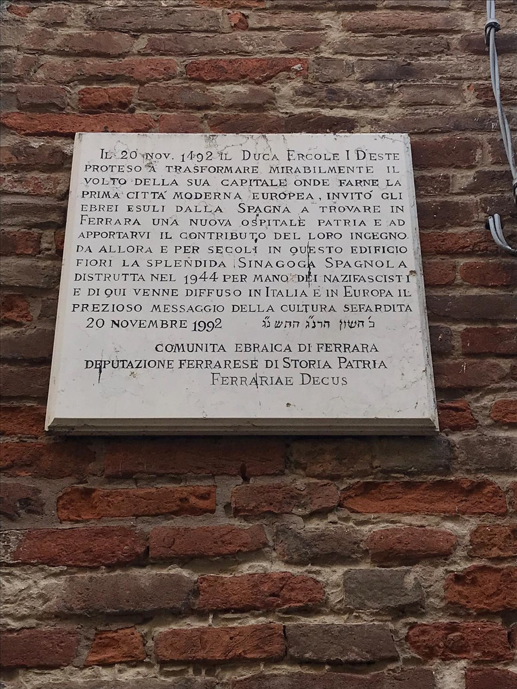 Lapide commemorativa dell'ex sinagoga di Ferrara, simbolo della memoria storica e culturale della comunità ebraica.