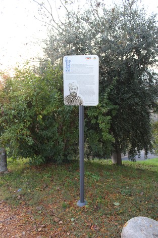 Targa informativa su Predrag, con illustrazione e testo descrittivo in un contesto di verde urbano.