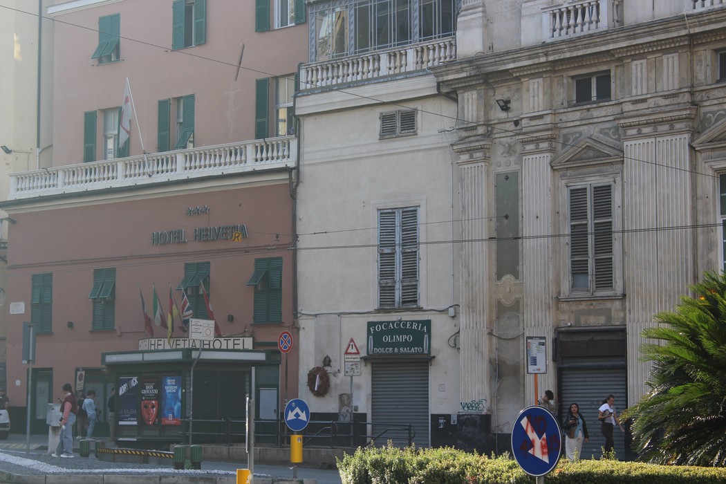 Immagine di una lapide commemorativa dedicata ai caduti per la Libertà, circondata da edifici storici.