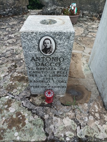 Monumento commemorativo dedicato ai caduti, con lapide in pietra e immagine del soldato.