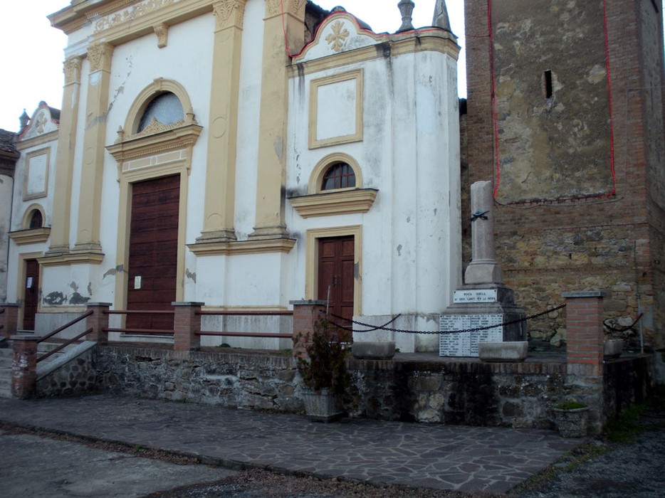 Monumento ai caduti di Rocca Susella, commemorazione dei sacrifici per la patria, situato accanto a un edificio storico.
