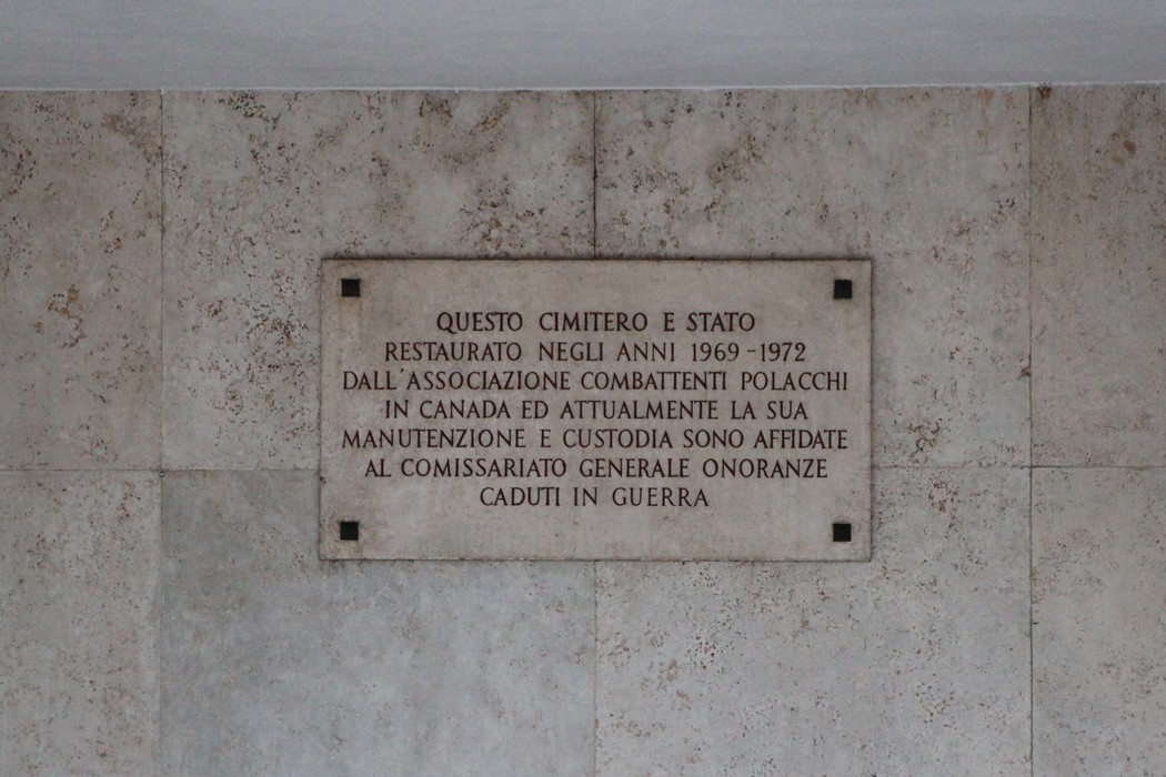 Cimitero di guerra polacco, monumento commemorativo con iscrizione su pietra e atmosfera di rispetto e memoria.