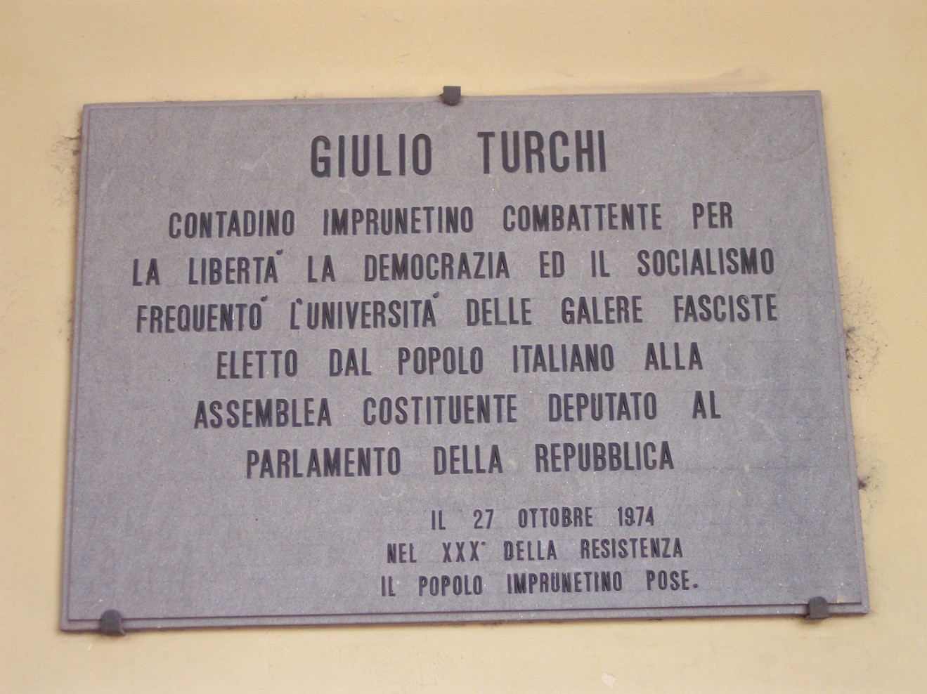 Lapide commemorativa dedicata a Giulio Turchi, attivista per la libertà e la democrazia, situata in Italia.