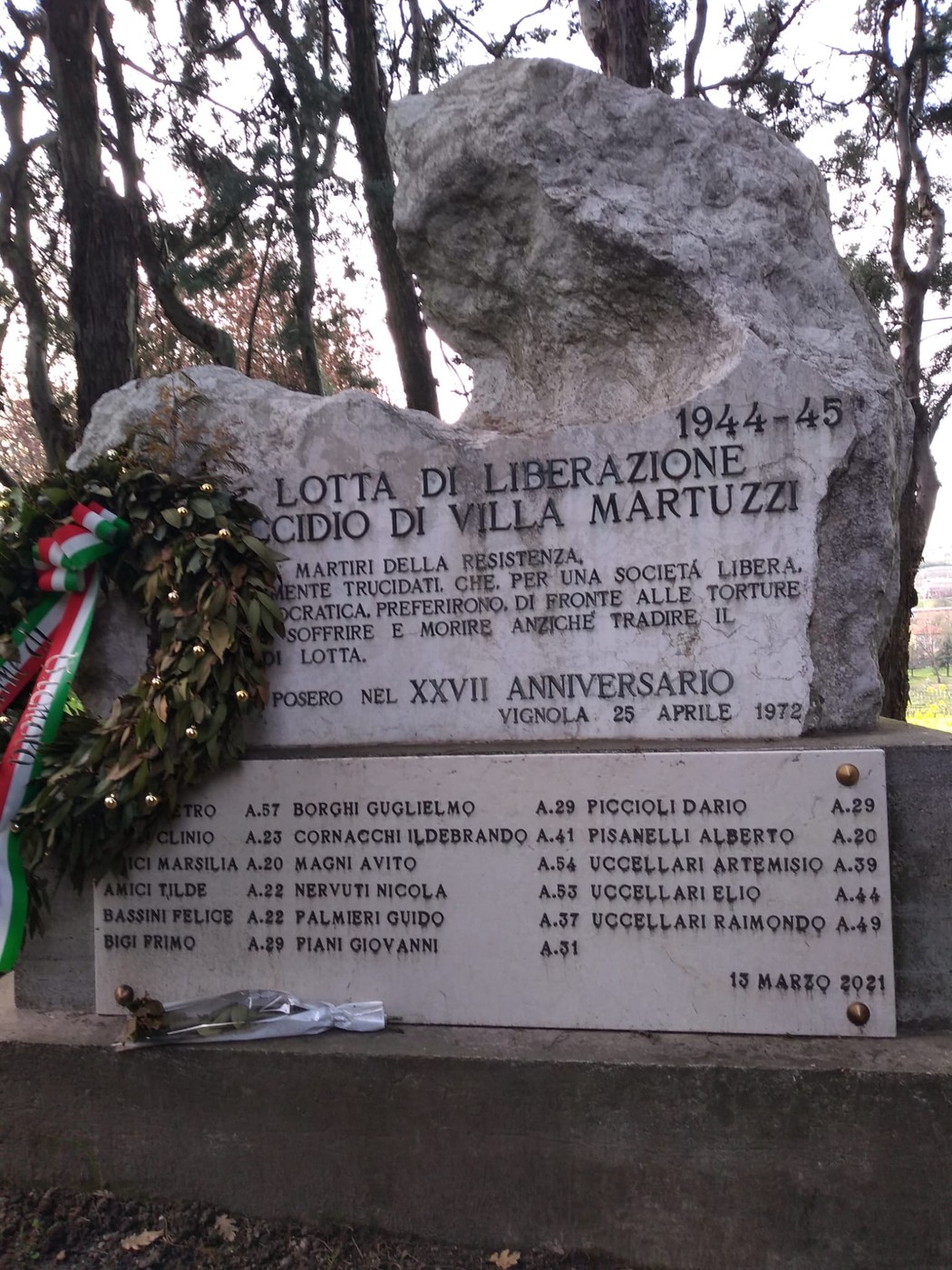 Monumento commemorativo per l'eccidio di Villa Martuzzi, con decorazioni floreali e iscrizioni in pietra.