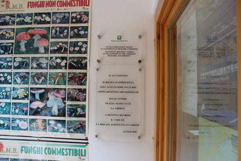 Targa commemorativa dedicata all'incendio di Valzurio su una parete.