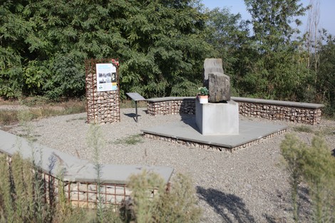 Monumento ai Martiri del Panaro, un luogo commemorativo circondato da vegetazione e architettura in pietra.