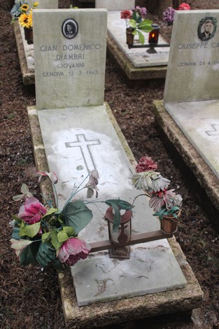 Tombe monumentali con fiori e tributi ai caduti per la Libertà in un cimitero. Atmosfera di rispetto e memoria.