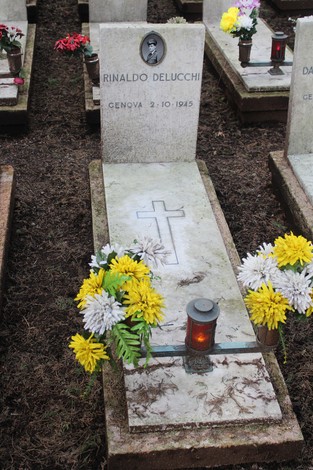 Tombe decorate con fiori e candele, dedicate ai caduti per la Libertà in un cimitero.