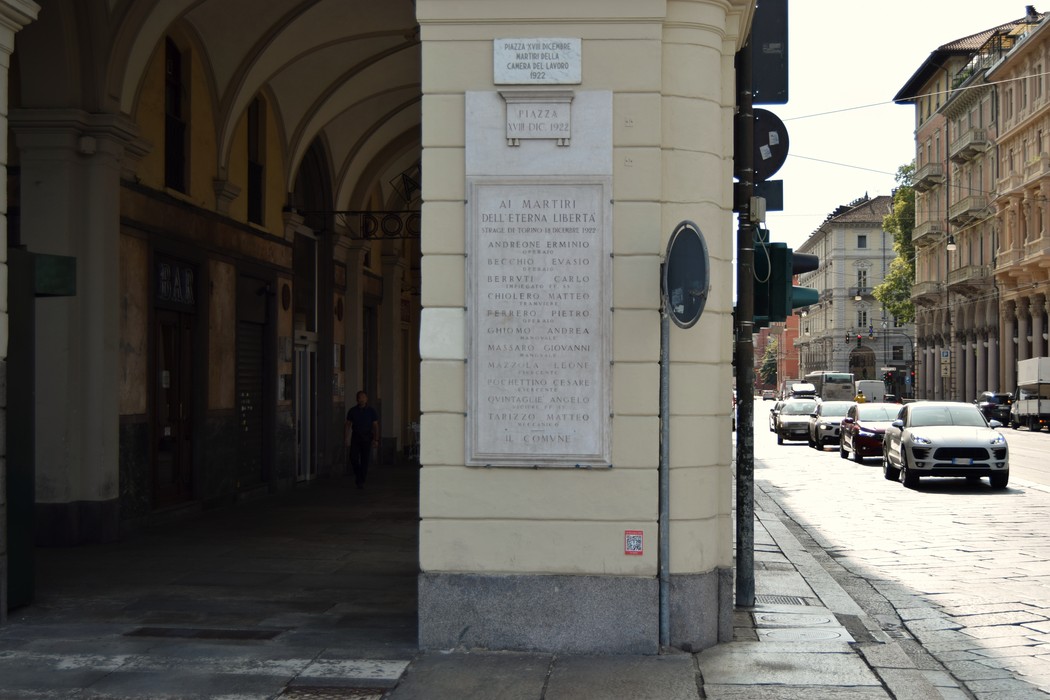 Lapide commemorativa dedicata ai martiri della Camera del Lavoro in un contesto urbano.