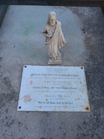 Una statua commemorativa e una targa al "Sacrario dei caduti di Kos", simbolo di memoria e rispetto.