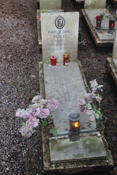 Tombe perpetue dei caduti per la Libertà, con candele e fiori decorativi su una lapide.