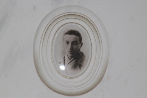 Ritratto di un giovane partigiano in un ovale bianco, in memoria dei combattenti per la libertà.