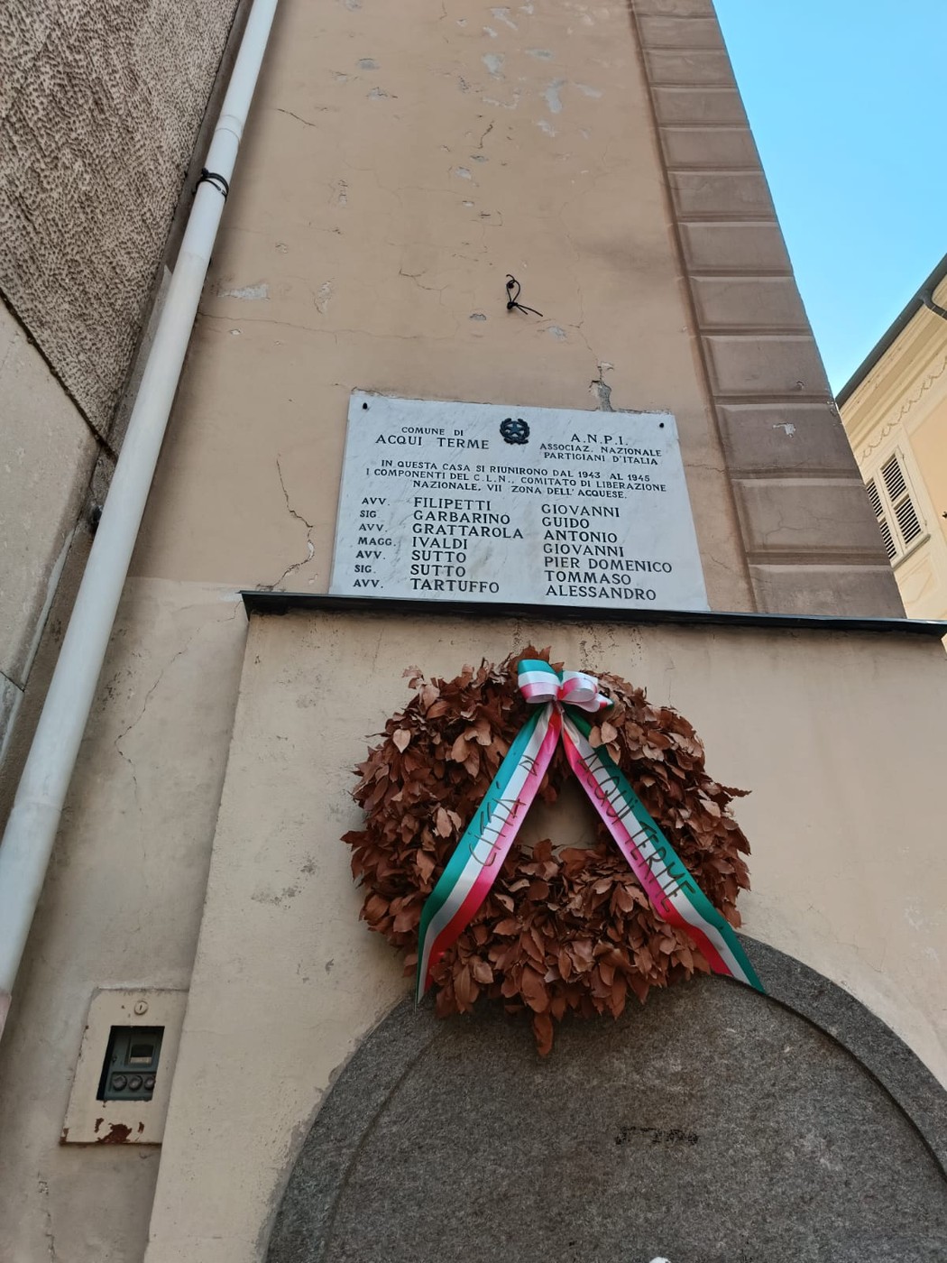 Lapide commemorativa del CLN acquese con la lista dei membri e una corona di alloro.