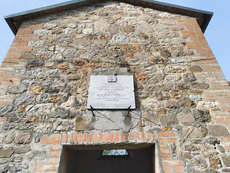 Lapide commemorativa agli Angiolini, incastonata in una muratura di pietra e mattoni.