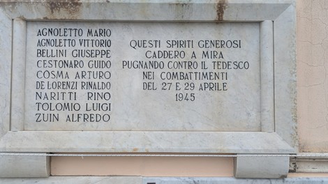 Lapide commemorativa dedicata ai caduti per la libertà, con nomi e date incisi su marmo.