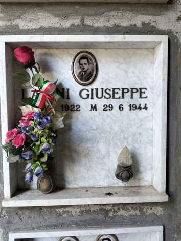 Ossario dei caduti di Cetica con decorazioni floreali e targa commemorativa di Giuseppe Loni.