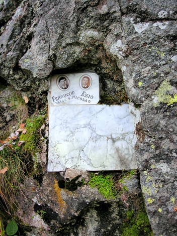 Lapidi commemorative incastonate nella roccia, con elementi di memoria storica e naturale.
