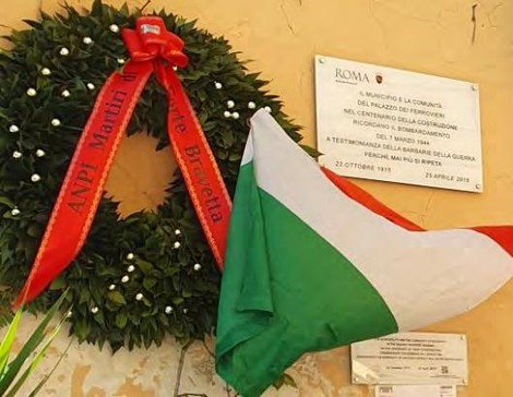 Lapide commemorativa con corona di alloro e bandiera italiana, in memoria del bombardamento del 7 marzo.