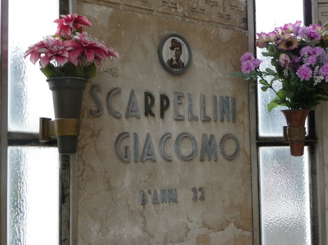 Sacrario ai caduti partigiani, con fiori artificiali e una targa commemorativa in memoria di un soldato.