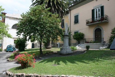 Monumento ai caduti di San Giuliano Terme, circondato da verde e architettura storica.