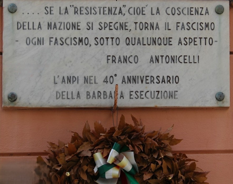 Lapidi commemorative dedicate a Ricciotti e Merlino, con ornamenti floreali e messaggi di resistenza.