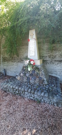 Monumento commemorativo dedicato a Artoni, Bolzoni e ai Mora, con decorazioni floreali e una base di pietre.