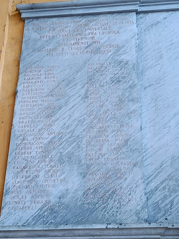 Lapide commemorativa dedicata ai caduti per la libertà, con nomi incisi su marmo.