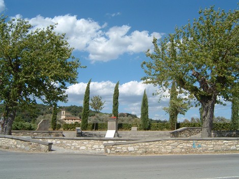 Area monumentale di Sant'Andrea, con alberi e un panorama sereno, incorniciata da un cielo nuvoloso.