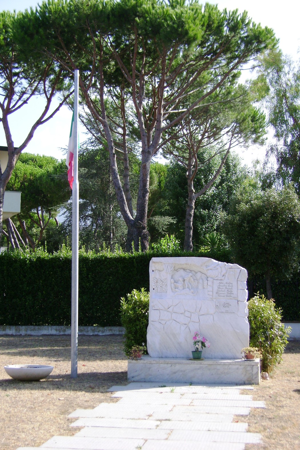 Monumento ai caduti civili, situato in un'area verde con alberi, dedicato alla memoria delle vittime.