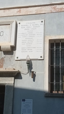 Lapide commemorativa dedicata ai caduti, affissa a un edificio, con nomi incisi in memoria dei soldati.