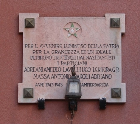 Lapide commemorativa ai partigiani caduti di Promontorio, decorata con una stella e una lampada.
