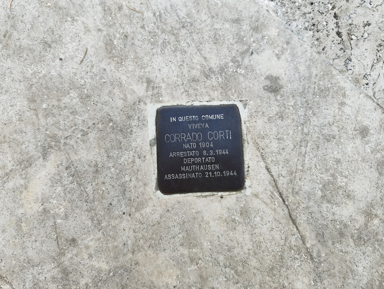 Pietra d'inciampo con nome e date in memoria di una vittima della deportazione.