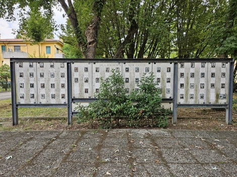 Lapidi commemorative in memoria dei caduti della seconda guerra mondiale, immerse nel verde di un parco.