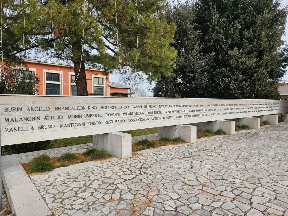 Monumento commemorativo dedicato alle vittime dell'eccidio di Villamarzana, con nomi incisi sulla pietra.