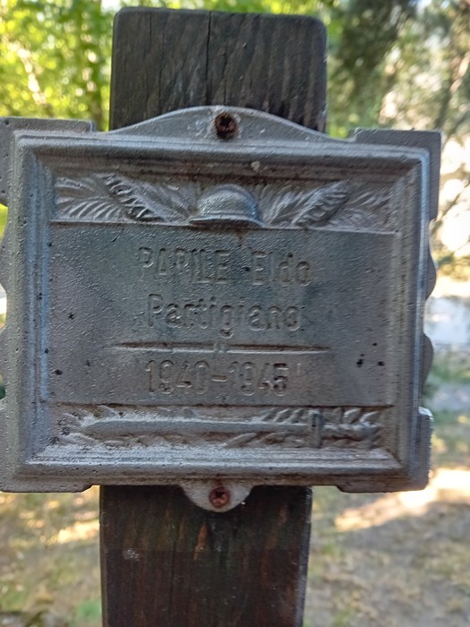 Targa commemorativa del "Parco della Rimembranza" dedicata ai partigiani, immersa nella vegetazione.