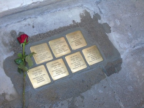 Pietre d'inciampo dedicate alla famiglia Dina - Corinaldi, con una rosa posata accanto.