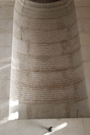 Interno del Sacrario del Ponte Monumentale, con iscrizioni commemorative su una parete. Atmosfera solenne e storica.