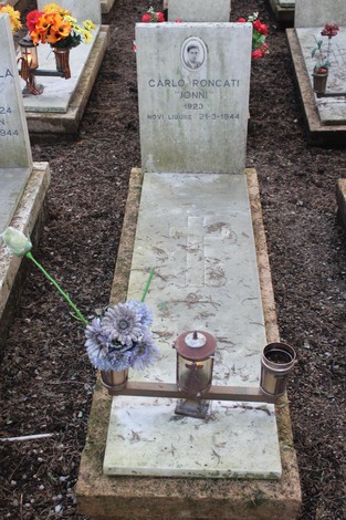 Tombe perpetue dei caduti per la Libertà, con fiori su alcune lapidi in un cimitero.