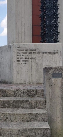 Monumento ai partigiani con elementi architettonici e iscrizioni dedicate alla memoria.