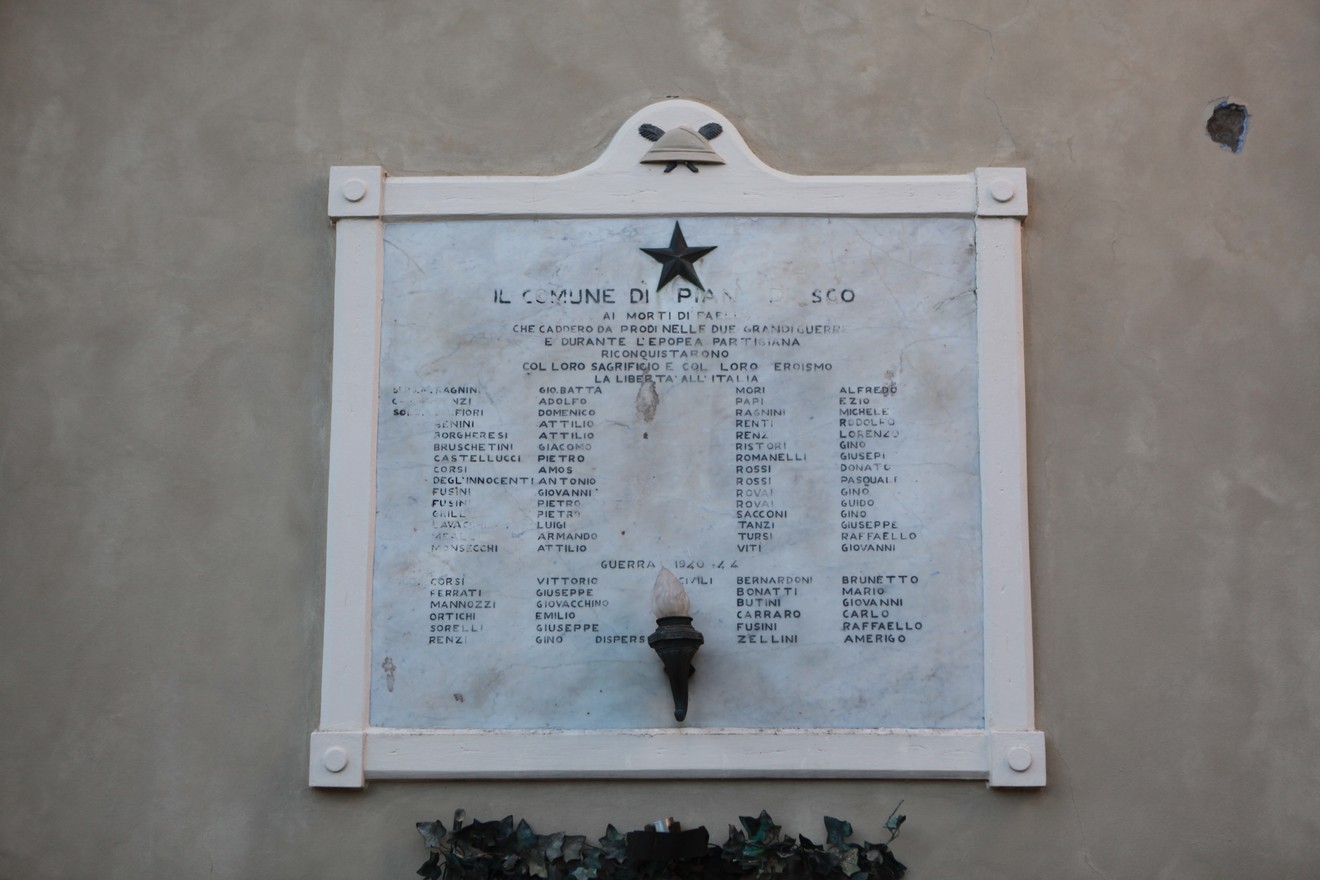 Lapide commemorativa ai caduti di Faella, con nomi dei soldati e simboli di onore e memoria.