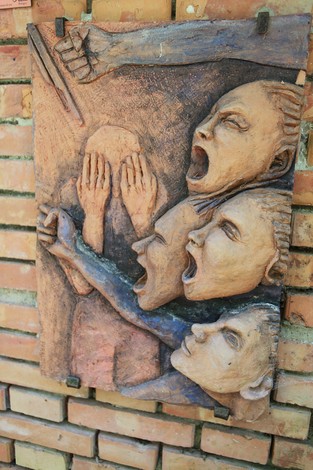 Monumento delle 128 partigiane, scultura che rappresenta volti espressivi e forti gesta simboliche di libertà.