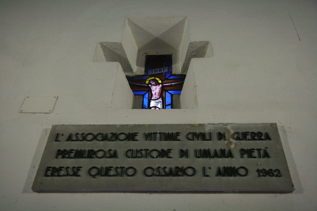 Cappella dei Martiri con vetrate artistiche e lapide commemorativa in un ambiente di riflessione.