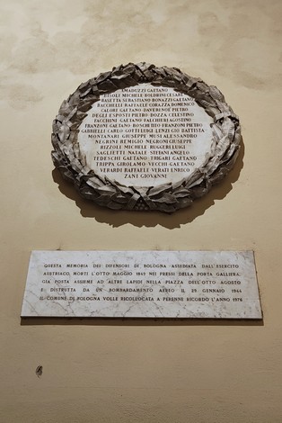 Lapide commemorativa con corona di laurel, dedicata alla ricostruzione e ai caduti di Bologna.