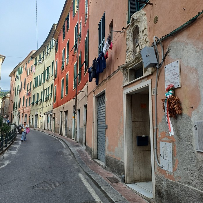Lapide con iscrizione sulla facciata di un edificio, all'ingresso su una via del centro storico.